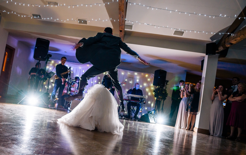 groom jumping over bride